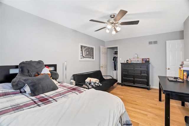 bedroom with visible vents, baseboards, light wood-style floors, and a ceiling fan