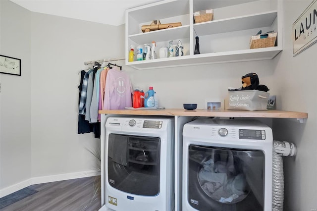 washroom with laundry area, wood finished floors, baseboards, and washing machine and clothes dryer