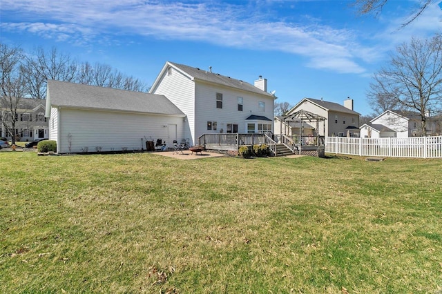 rear view of house with a fire pit, fence, a lawn, a deck, and a patio