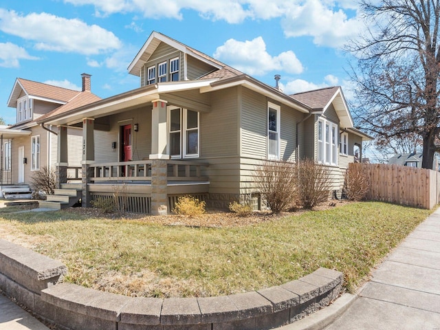 view of home's exterior featuring a yard, covered porch, and fence