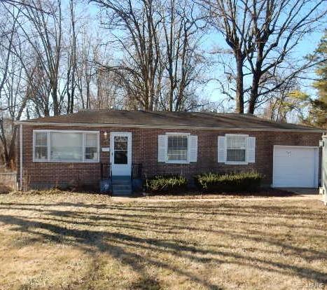 ranch-style house featuring a front yard, brick siding, an attached garage, and entry steps