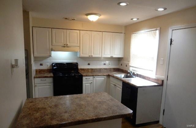 kitchen featuring under cabinet range hood, a peninsula, electric range, white cabinets, and a sink