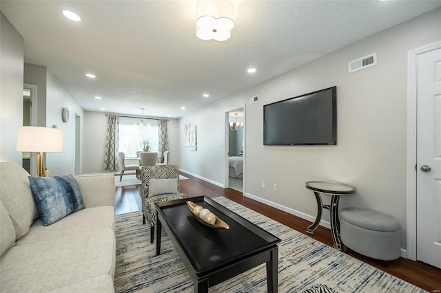 living area with recessed lighting, visible vents, baseboards, and wood finished floors