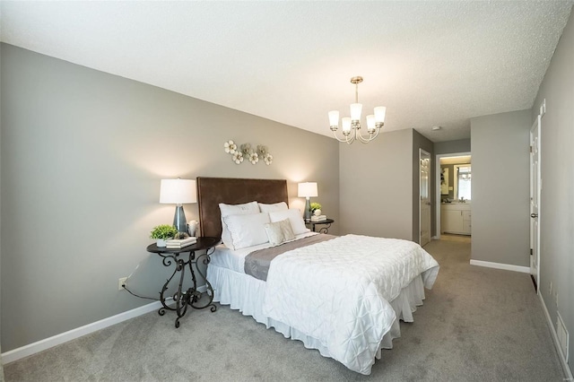 carpeted bedroom with an inviting chandelier, ensuite bathroom, and baseboards