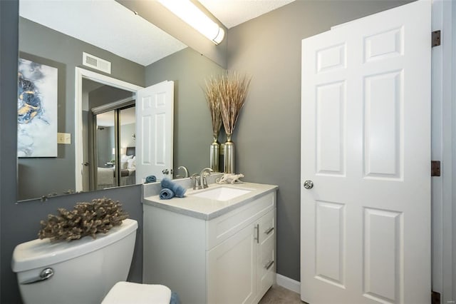 half bath featuring visible vents, toilet, and vanity