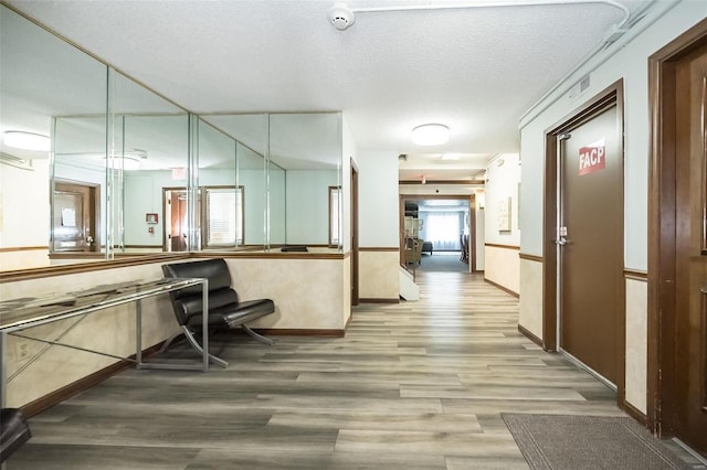 interior space with a textured ceiling and wood finished floors