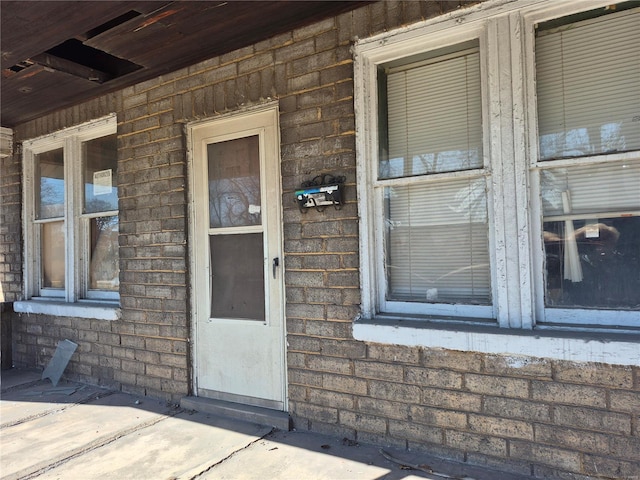 doorway to property featuring brick siding