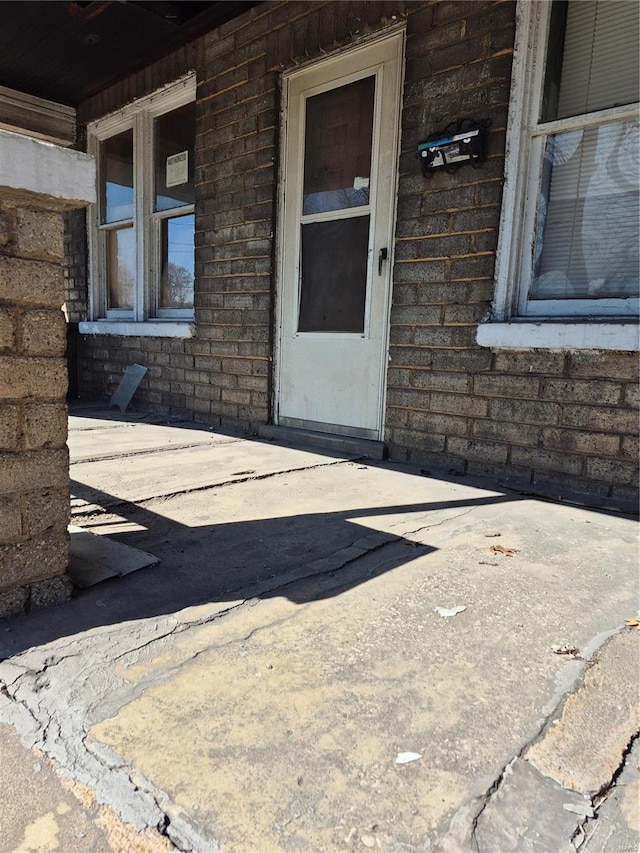 doorway to property with brick siding