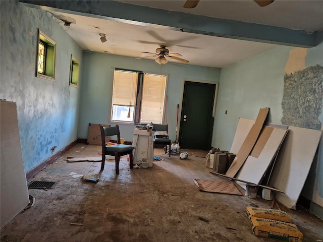 interior space with baseboards, beam ceiling, and ceiling fan