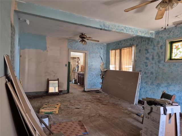 misc room featuring beamed ceiling, wallpapered walls, and a ceiling fan