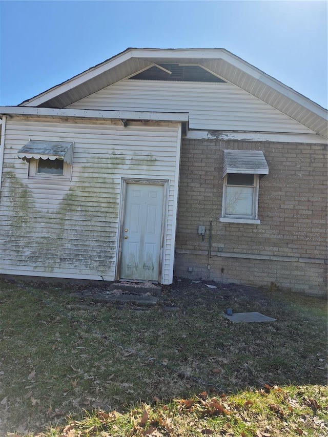 back of house with a yard and brick siding