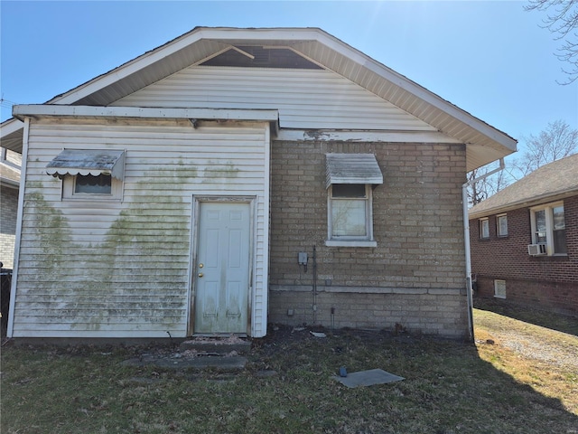 back of house featuring brick siding and cooling unit