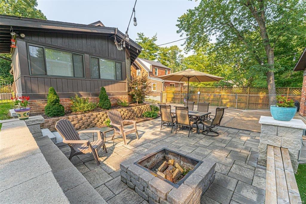 view of patio featuring outdoor dining space, a fire pit, and fence