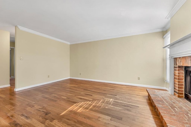 unfurnished living room with baseboards, light wood-style floors, a brick fireplace, and ornamental molding