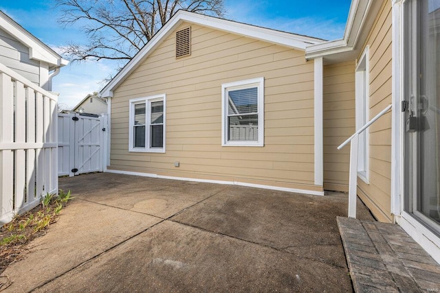 exterior space featuring a gate, fence, and a patio area