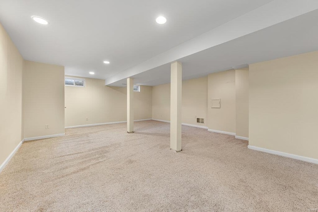 below grade area with light carpet, visible vents, recessed lighting, and baseboards