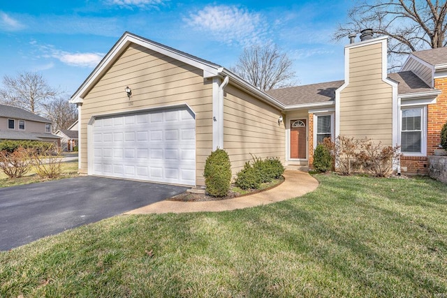 ranch-style home with a garage, driveway, a chimney, and a front yard