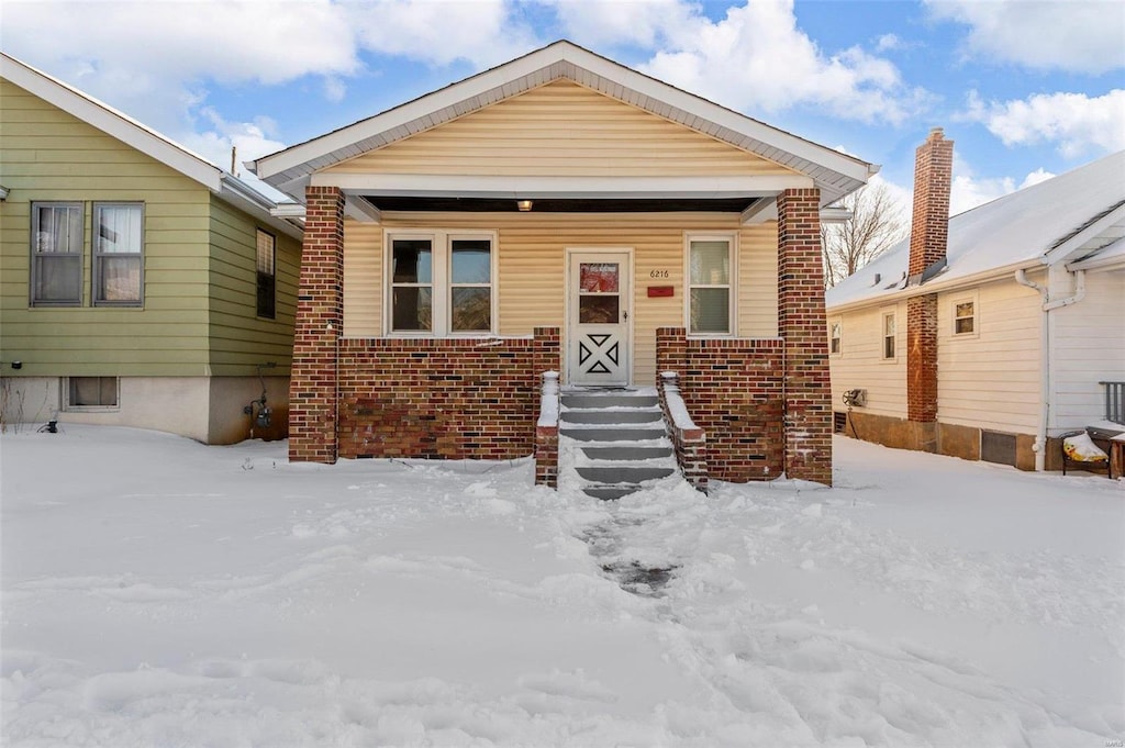 view of front facade featuring covered porch and brick siding