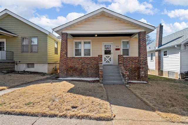 view of front facade with brick siding and a porch