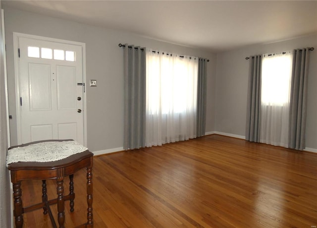 foyer featuring baseboards and wood finished floors