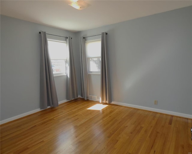 spare room with visible vents, baseboards, and light wood-style flooring