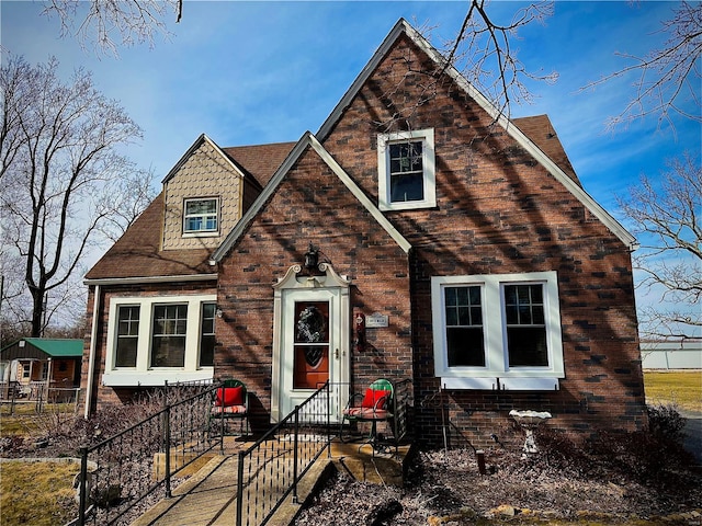 view of front of home featuring fence and brick siding