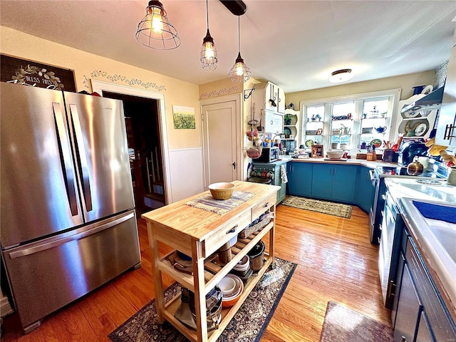 kitchen featuring light countertops, freestanding refrigerator, light wood-style floors, blue cabinets, and open shelves