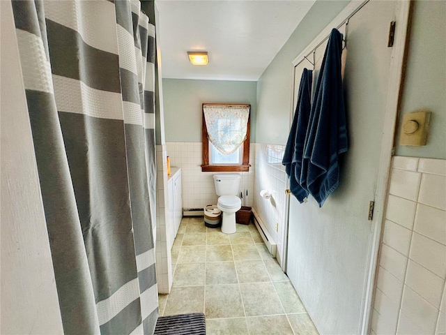 bathroom with tile patterned floors, a wainscoted wall, toilet, tile walls, and baseboard heating