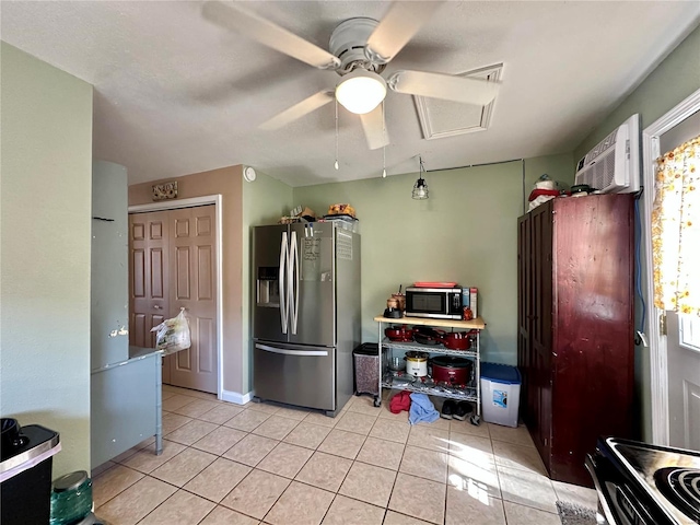 kitchen with light tile patterned floors, appliances with stainless steel finishes, a wall mounted air conditioner, and a ceiling fan