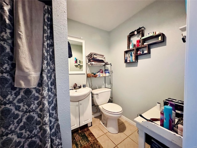 full bath featuring toilet, vanity, and tile patterned flooring