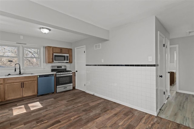 kitchen featuring visible vents, a sink, light countertops, dark wood-type flooring, and appliances with stainless steel finishes