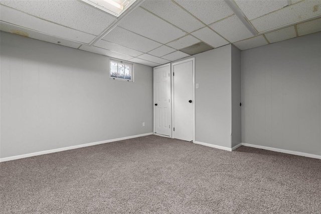 below grade area with carpet, baseboards, and a paneled ceiling