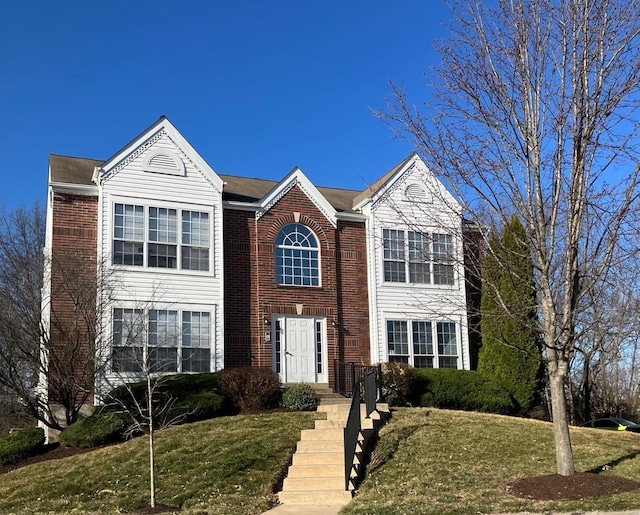 view of front of home featuring brick siding and a front yard