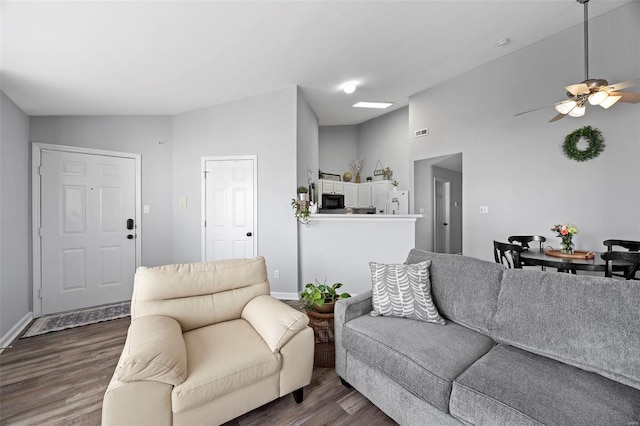 living room featuring lofted ceiling, dark wood-style floors, baseboards, and ceiling fan