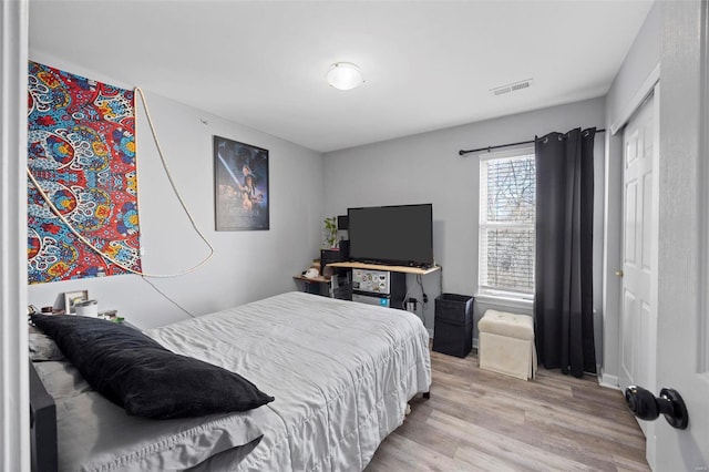 bedroom featuring visible vents and wood finished floors