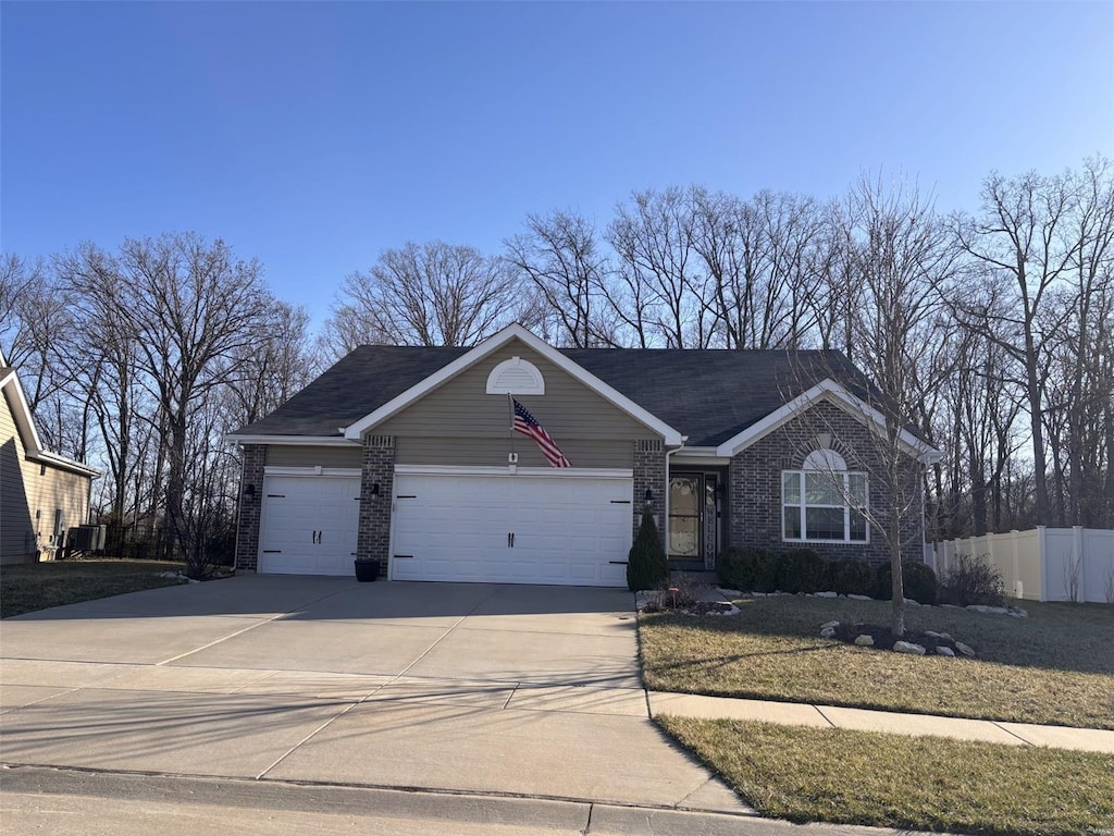 ranch-style home featuring brick siding, an attached garage, driveway, and fence