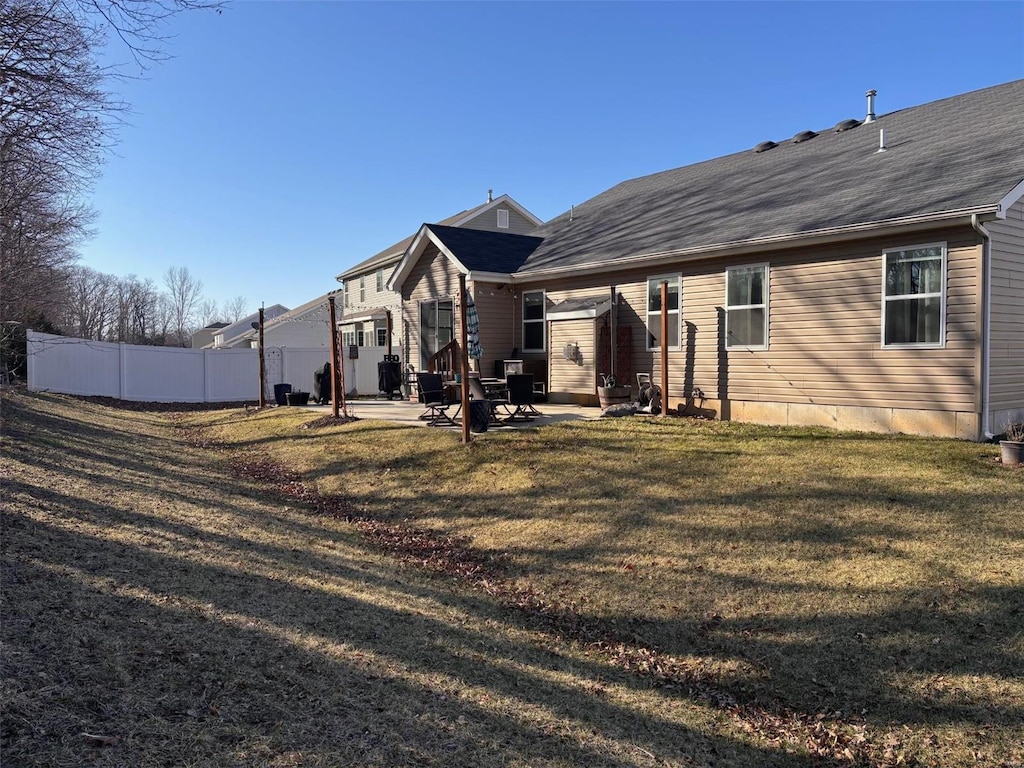 rear view of house featuring a yard, a patio, and fence