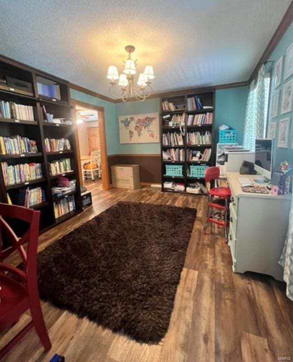 interior space with a textured ceiling, crown molding, an inviting chandelier, and wood finished floors