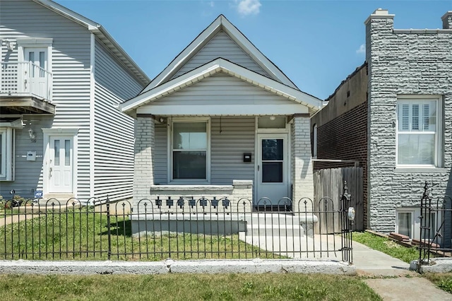 view of front facade with covered porch and a fenced front yard