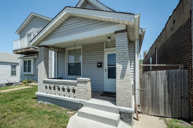 shotgun-style home featuring a porch and fence