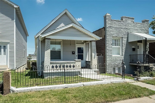 view of front of property featuring a fenced front yard, stone siding, and a porch