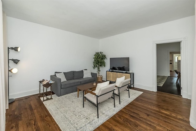 living area featuring baseboards and dark wood-style flooring