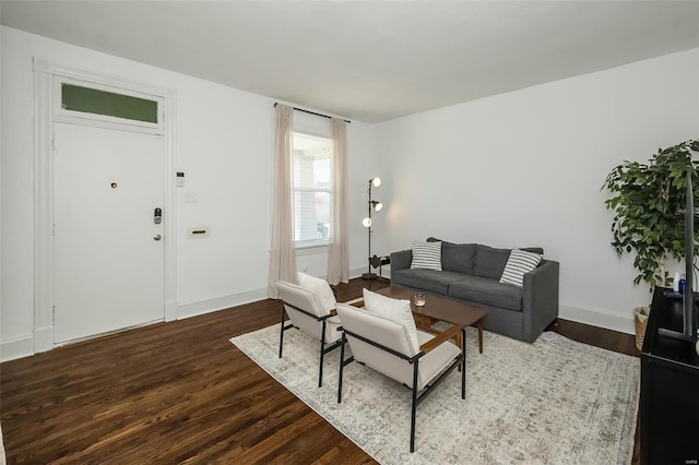 living area with baseboards and dark wood-style flooring