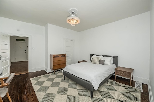 bedroom featuring visible vents, wood finished floors, and baseboards