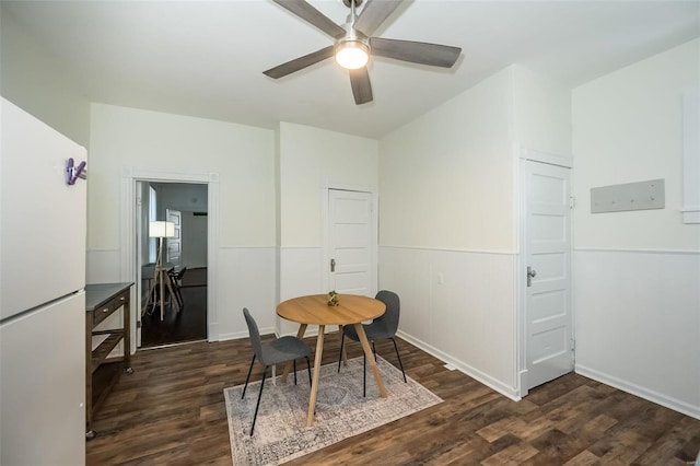 dining space featuring wainscoting, ceiling fan, and dark wood-style flooring