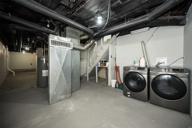 unfinished below grade area featuring heating unit, separate washer and dryer, and electric water heater