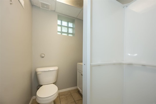 bathroom with tile patterned floors, visible vents, toilet, baseboards, and a paneled ceiling