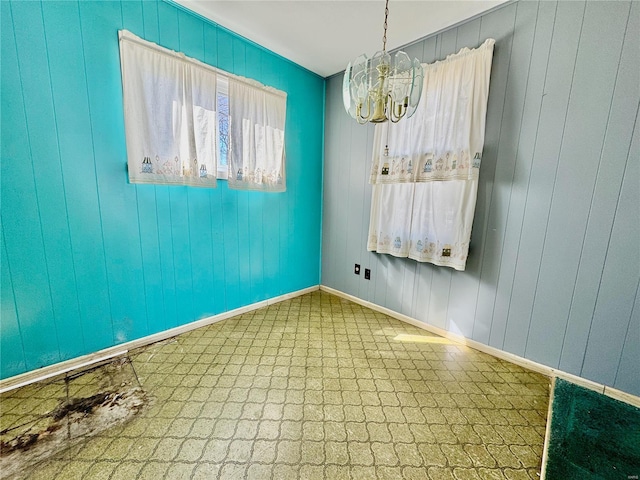 unfurnished room featuring tile patterned floors, a chandelier, and baseboards