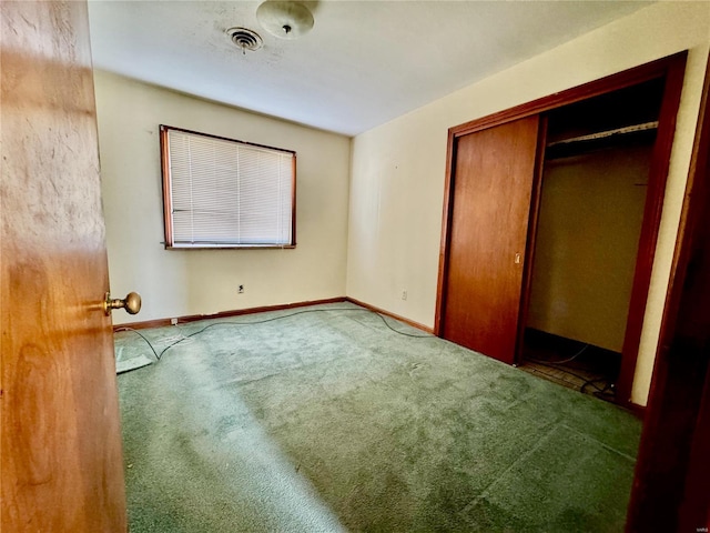 unfurnished bedroom with carpet flooring, visible vents, baseboards, and a closet