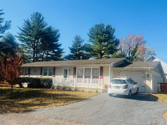 ranch-style house with aphalt driveway, an attached garage, and a porch